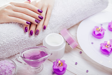 Obraz na płótnie Canvas Beautiful purple manicure with spa essentials