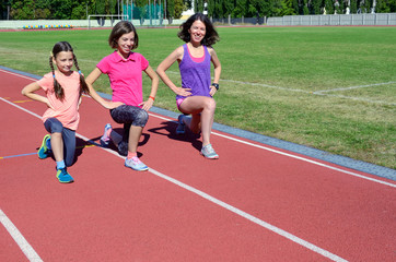Family sport and fitness, happy mother and kids exercising and running on stadium track outdoors,...