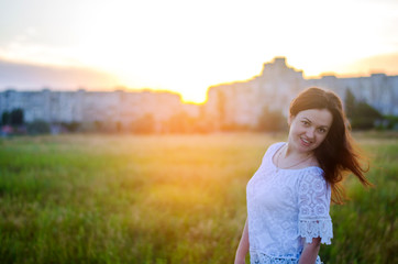 Portrait of a young  beautiful girl on nature. summer sunset. happy brunette. outdoor. place for text