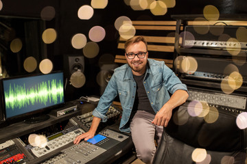 man at mixing console in music recording studio