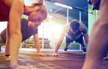 Fototapeta na wymiar group of people doing straight arm plank in gym