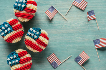 flat lay with arranged cupcakes and american flags on wooden tabletop, presidents day celebration...