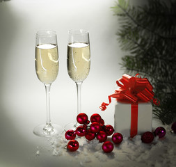 two glasses with champagne, and boxes with gifts on Christmas b