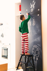 little boy drawing on chalkboard in his home