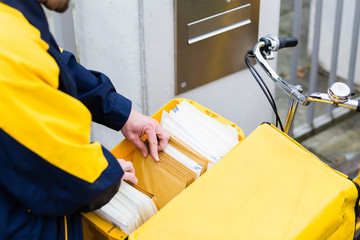 Postman delivering letters to recipient mailbox