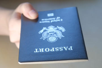 Persons hand holding a passport of United States