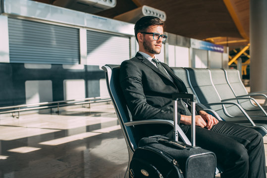 Young business man sitting at the airport waiting for the flight