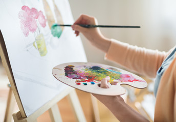 artist with palette painting at art studio