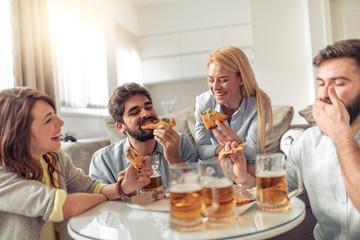 Group of friends eating pizza at home