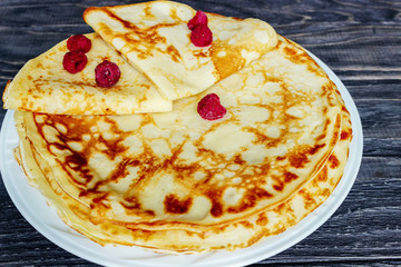 Pancakes on a white plate with honey and a cup of milk. Tasty breakfast.