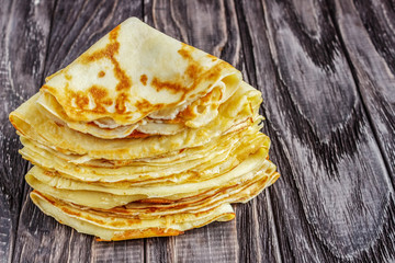 Pancakes on a white plate with honey and a cup of milk. Tasty breakfast.