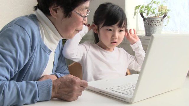 孫とパソコンを使うシニア