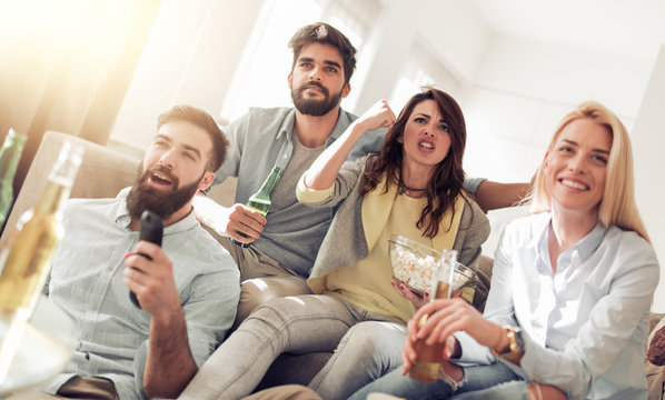 Cheerful group of friends watching football game