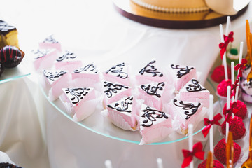 Delicious and tasty dessert table with cupcakes shots at reception closeup