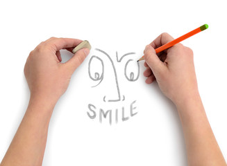 Hands of an artist draw a smile on white paper