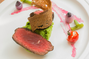 grilled red beef and toast on mashed spinach, top view of roast meat