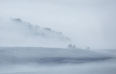 Clouds and fog over a snow covered plateau in the mountains. Vercors, France.