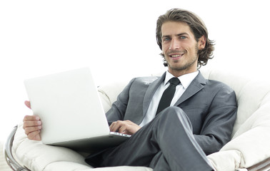 modern businessman with a laptop sitting in a stylish comfortable chair