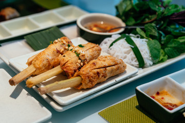 Vietnamese Meatball Wraps (Nam Neung) served with vegetables, rice noodles and sauce at the restaurant in Hanoi, Vietnam.