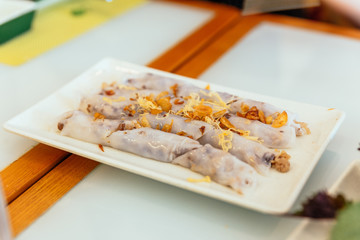 Vietnamese Fresh Spring Rolls topping with garlic and served in white plate at the restaurant in Hanoi, Vietnam.