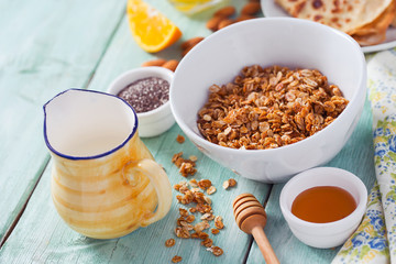 breakfast with home made granola and pancakes on turquoise surface