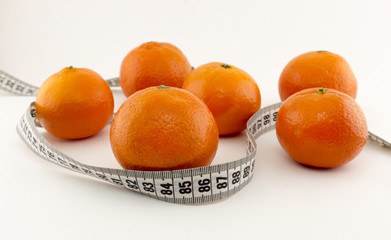 Mandarins and centimeter tape on a white background