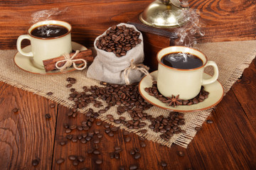a linen bag full of coffee beans with a cup of freshly brewed black coffee with free space for text