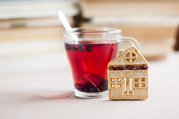 blueberry tea in a glass bowl with shortbread cookies  in the form of a house against the...