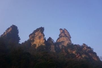 Mountains in China with trees and dust in sunshine