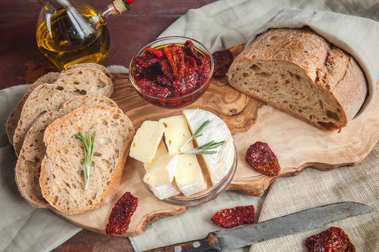 Bread whole wheat processed cheese Camembert with sun-dried tomatoes with rosemary and olive oil.