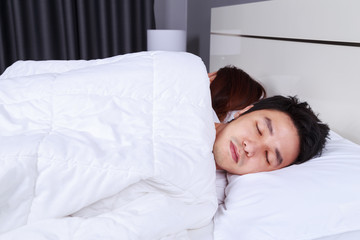 sick man sleeping on bed with his wife