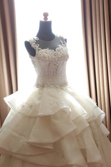 Fototapeta na wymiar White wedding dress gown on mannequin. Bride's morning wedding preparation concept