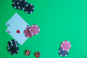 Poker game concept with chips, cards on green background. Top view, copy space