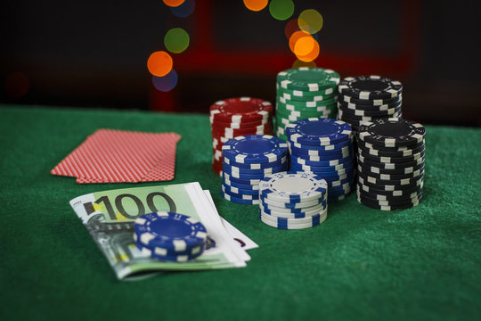 Poker chips, euros and cards on the green table