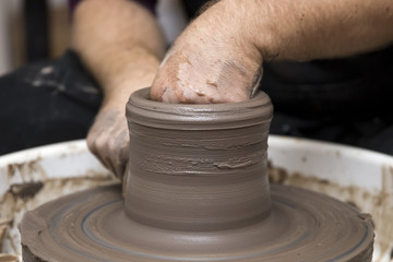 Artist makes clay pottery on a spin wheel