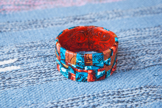 Ethnic jewellery bracelet on Blue fabric. Handmade jewelry bracelet of polymer clay.Fashion background with bagle bracelet.