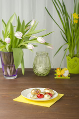 Easter tree and flowers with chocolate eggs on a wooden table