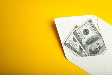 Dollars in an envelope on a yellow background.