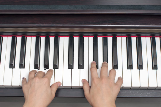 Piyano çalan çocuk, tuşlar ve eller.