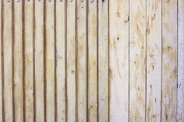 A simple wooden fence is made of various wooden boards. Wooden texture