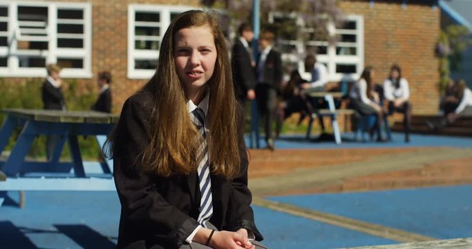4K Portrait sad lonely girl feeling all alone outdoors in the school yard. Slow motion