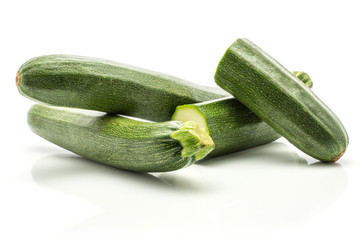 Two green zucchini and two sliced halves isolated on white background long raw courgette.