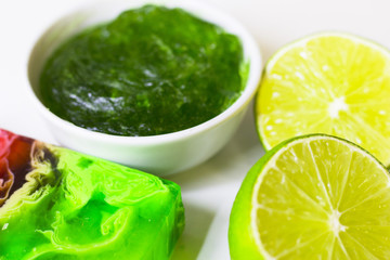 Lime oil skin and hair care home spa. Bottle of oil, jar of mask, green soap. White board background