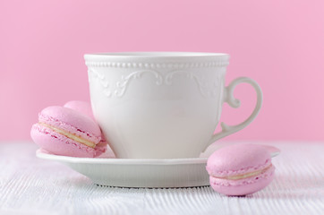 coffee cup with pink macaroons on pink background
