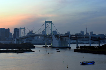 Fototapeta premium Tokyo, Japan - April 16, 2017 : View of Tokyo Bay, Rainbow bridge and Tokyo Tower landmark, sunset scene, Odaiba city on April 16, 2017 at Tokyo Japan