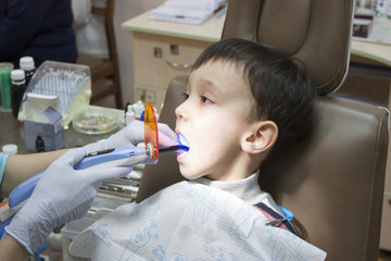 Dentist is treating a boy's teeth