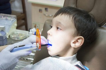 Dentist is treating a boy's teeth