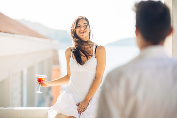 Attractive woman drinking cocktail and enjoying her summer vacation.Drinking refreshing drink and smiling to a man.Flirting and seduction.Man approaching to a woman.Attracted people.One night stand