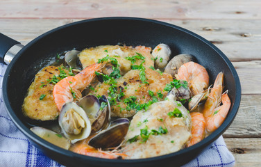 Hake slices cooked with prawns and clams.