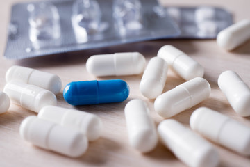 Blue and white tablets on a blue background. Spilled Capsules